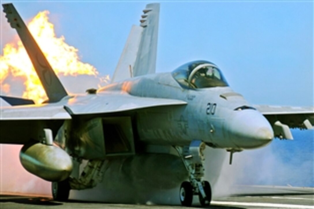 An F/A-18E Super Hornet belches fire as it launches from the flight deck of the aircraft carrier USS Abraham Lincoln in the Pacific Ocean, Feb. 2, 2009. The USS Abraham Lincoln is conducting sustainment training and carrier qualifications.