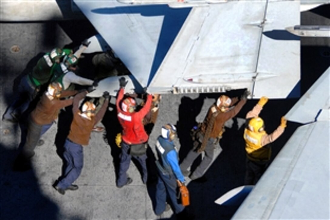 U.S. Navy flight deck crewmembers push back an F/A-18C Hornet aboard the aircraft carrier USS Abraham Lincoln in the Pacific Ocean, Jan. 30, 2009. The USS Lincoln is on a scheduled work-up conducting training and carrier qualifications.
