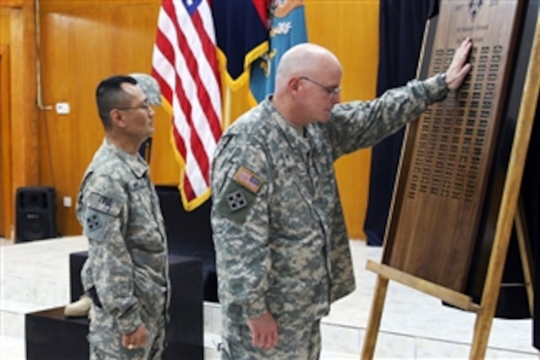 U.S. Army Lt. Col. James Carter touches an end-of-tour memorial plaque for fallen soldiers following a dedication ceremony at the chapel on Camp Liberty, Iraq, Feb. 3, 2009. Master Sgt. Billy Arnold, the noncommissioned officer in charge, stands next to him. The plaque contains the names of 94 soldiers who gave their lives in the service of their nation and the people of Iraq while deployed for 15 months. Carter is the chaplain for the 4th Infantry Division and Multinational Division Baghdad.