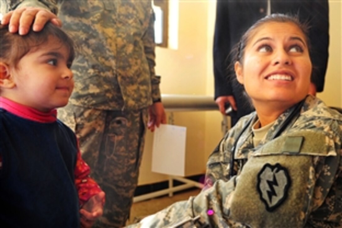 U.S. Army 1st Lt. Maribel Andrade provides aid to a little girl from Samarra, Iraq, and lets her parents know her condition at the Samarra clinic, Feb. 3, 2009. Andrade is assigned to 25th Infantry Division's Headquarters Company, 2nd Infantry Battalion, 35th Infantry Regiment, 3rd Brigade Combat Team.