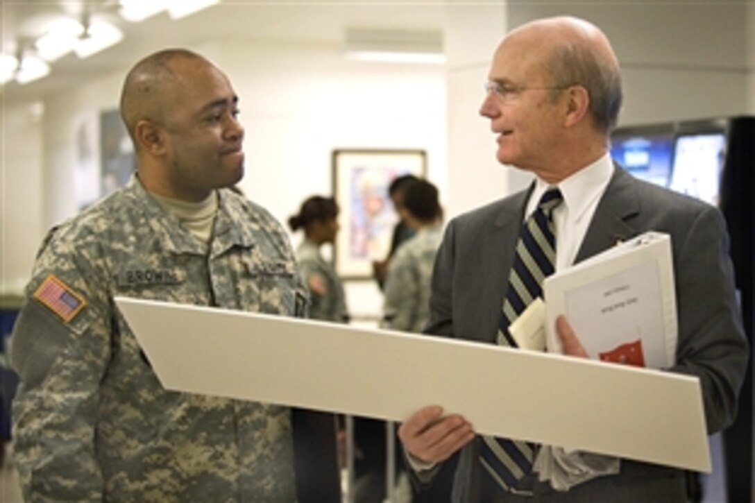 Army Secretary Pete Geren talks with Sgt. 1st Class Craig Browne from the U.S. Army Reserve Command about a photo of Browne's grandfather after a rededication ceremony for a Buffalo Soldier memorial in the halls of the Pentagon, Feb. 5, 2009. Browne's grandfather was a Buffalo Soldier with the 9th Cavalry Division.