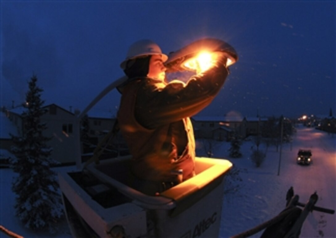 U.S. Air Force Senior Airman Scott Brown uses a 45-foot reach bucket truck to replace the bulb of a streetlamp at Eielson Air Force Base, Alaska, on Feb. 2, 2009.  Airmen on the base provide constant maintenance on the streetlights in the winter months due to the increased amount of wear and tear.  