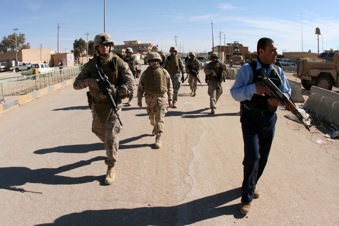 Reserve Marine Capt. Justin Martell (front, left), the battalion judge advocate for 2nd Battalion, 25th Marine Regiment, makes his way to the courthouse on a joint foot patrol Feb. 5, 2009.  During his seven-month tour in Iraq, Martell helped to successfully coordinate efforts of Coalition and Iraqi Security Forces. In his civilian career Martell is an attorney with the U.S. Office of Special Counsel in Washington, D.C. The Marine Corps Reserve officers deployment opportunities for officers of all rank and occupational specialty.