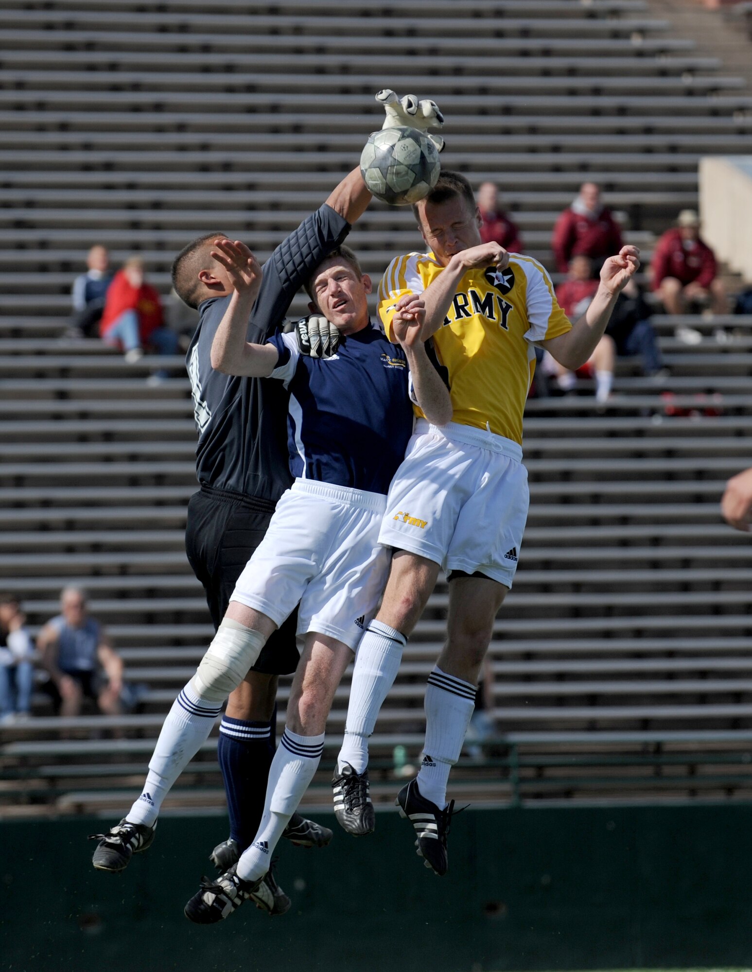 ABILENE, Texas -- Navy goalie Airman Randy Luck and defenseman Petty Officer 3rd Class Patrick O'Brian attempt to stop a header from Army Specialist Michael Lamb here, Feb. 6.  The All Army Soccer Team defeated the All Navy Team 2-1 to improve their record to two wins, two losses, and one tie. The All Navy Teams record stands at two wins, two losses, and one tie in the U.S. Armed Forces Soccer Championship.  (U.S. Air Force photo by Staff Sgt. Alan Garrison)
