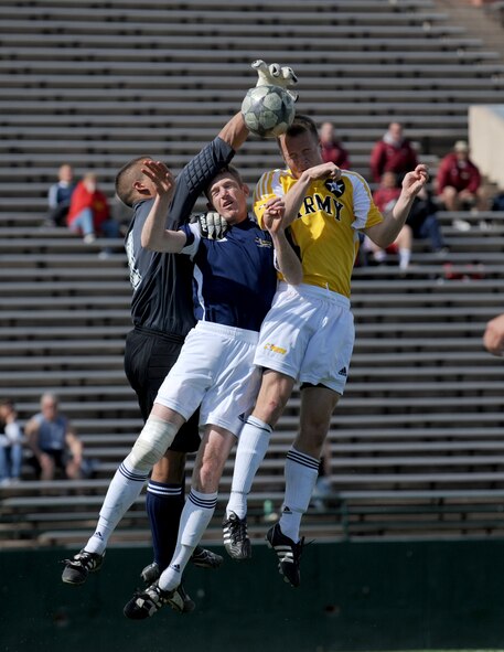 ABILENE, Texas -- Navy goalie Airman Randy Luck and defenseman Petty Officer 3rd Class Patrick O'Brian attempt to stop a header from Army Specialist Michael Lamb here, Feb. 6.  The All Army Soccer Team defeated the All Navy Team 2-1 to improve their record to two wins, two losses, and one tie. The All Navy Teams record stands at two wins, two losses, and one tie in the U.S. Armed Forces Soccer Championship.  (U.S. Air Force photo by Staff Sgt. Alan Garrison)