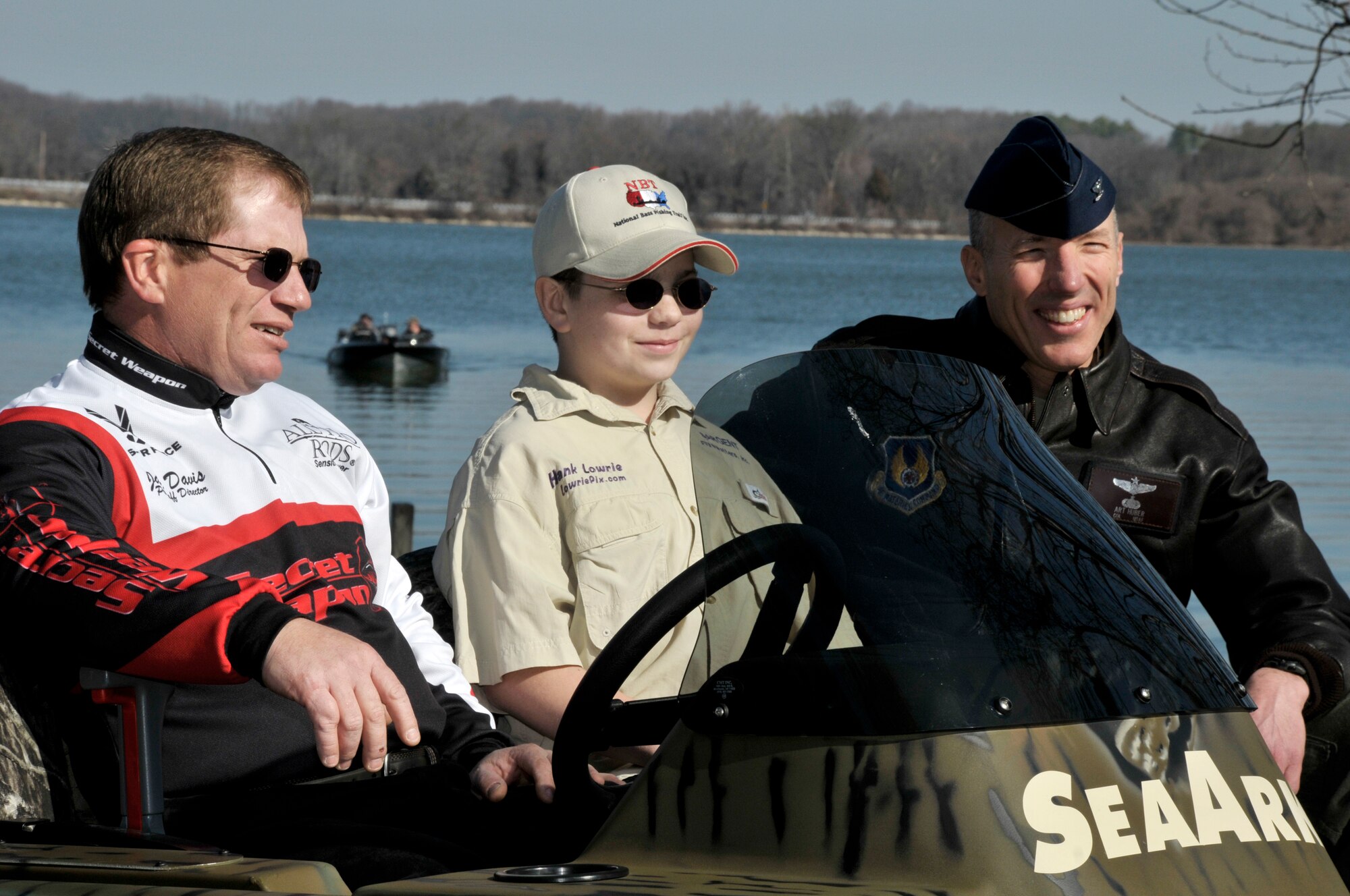 (L-R) Jake Davis, National Sales Director for All Pro Rods, Hank Lowrie and AEDC Commander Col. Art Huber sit onboard a boat being launched at Morris Ferry Dock commemorating the official re-opening of the ramp to the public Friday. Lowrie, the son of David Lowrie and grandson of Jim Lowrie, all of whom attended Friday’s ceremony, is the fourth generation of fishermen who have fished on Woods Reservoir.  Jim’s father, Harold, began the legacy in the 1950s. (Photo by Rick Goodfriend)