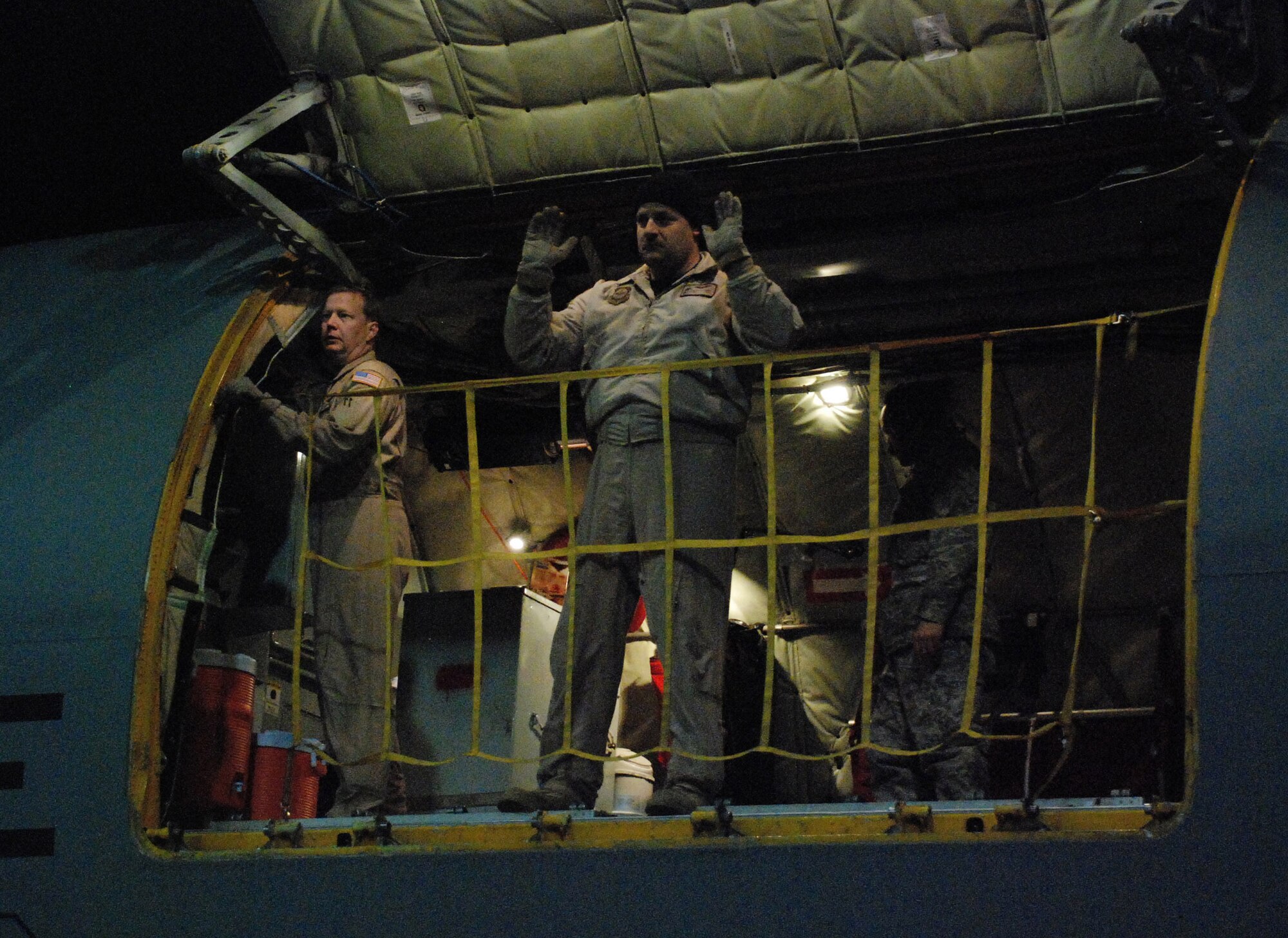 Tech. Sgt. Warren Bearup communicates with flightline personnel at Bagram Airfield, Afghanistan, from a KC-135 Stratotanker cargo door. He was one of eight reservists from the 931st Air Refueling Group to volunteer for a 12-day aeromedical evacuation mission that involved four trips in and out of Afghanistan. To his left is Master Sgt. Darren Demel, the only member of the crew to volunteer for one of the 931st's previous Afghanistan missions. Both sergeants are boom operators assigned to the 18th Air Refueling Squadron, the flying unit of the 931st. (U.S. Air Force photo) 
