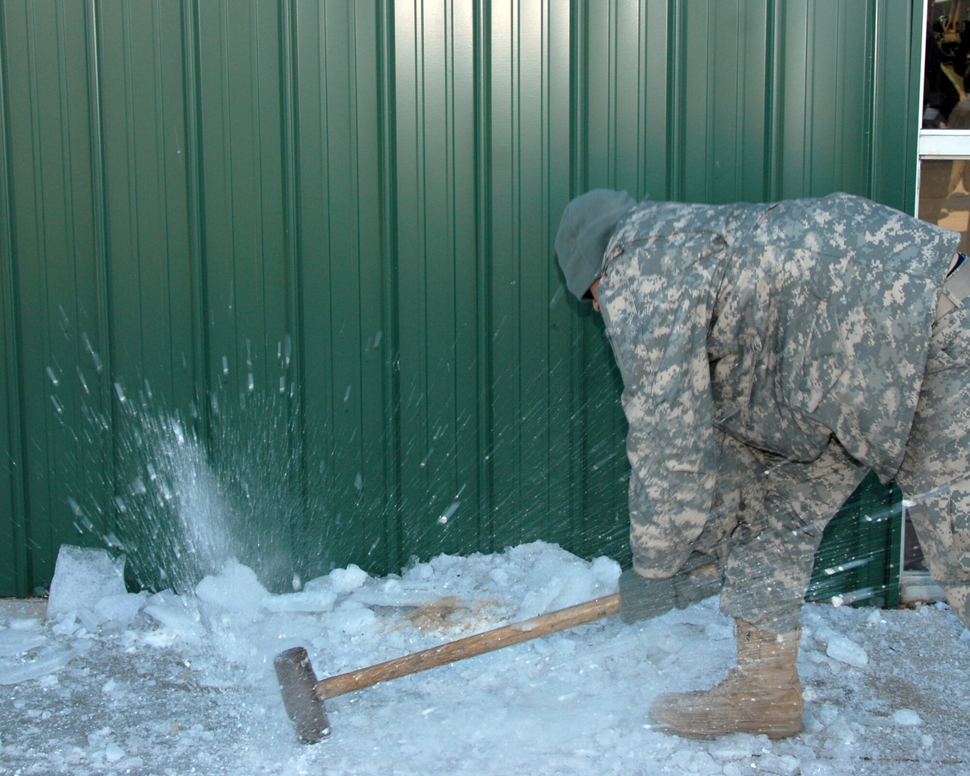 Kentucky Army National Guard member, PFC Donald Jones, Bravo Battery, Campellsville, Kentucky.  Pictured here busting ice from the sidewalk to the LaCenter relief center.