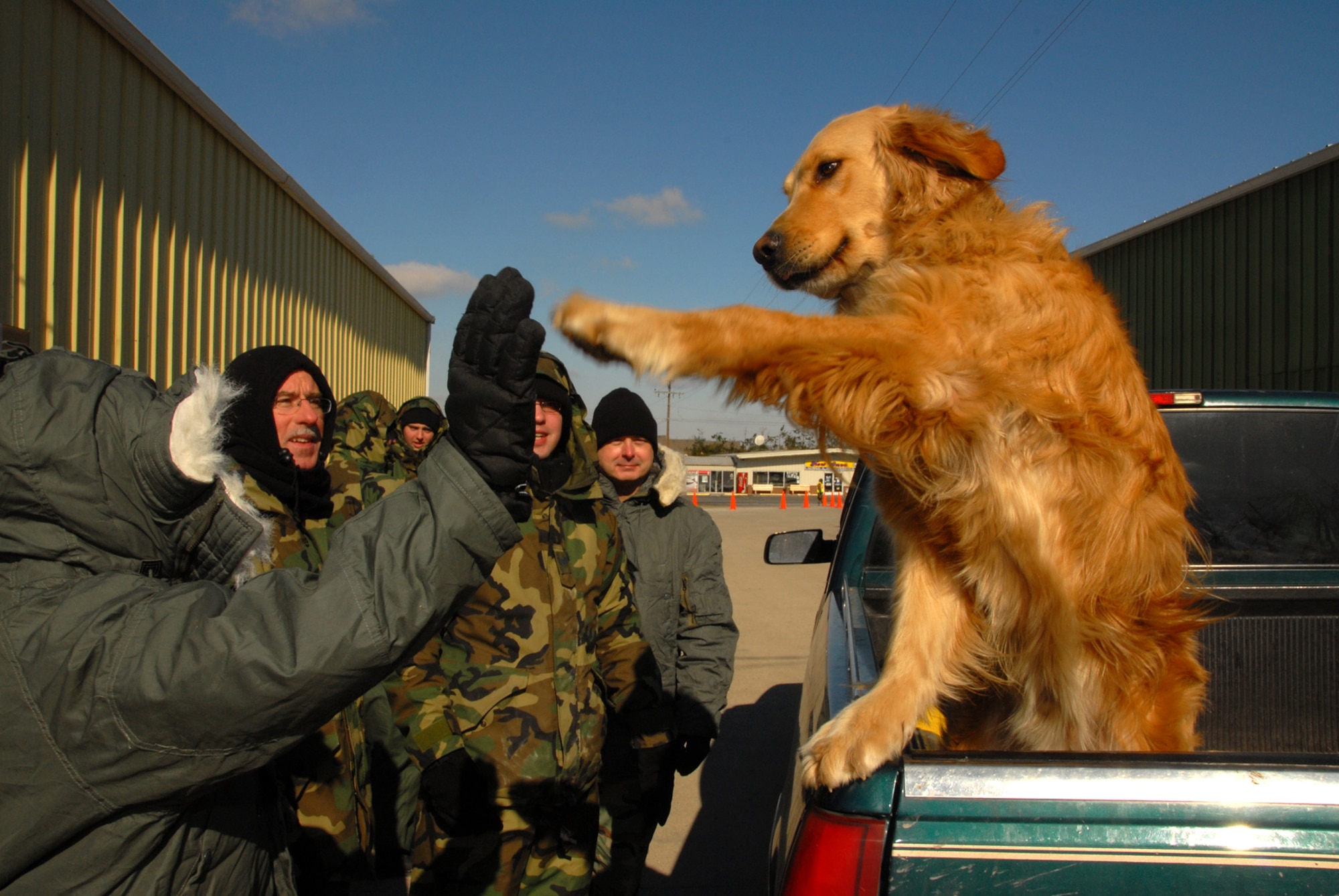 MSgt Karen Fulton, from the Kentucky Air National Guard, 123rd MPF, Shares a light hearted moment with a victim of the ice storms dog, exchanging high fives at the LaCenter, Kentucky relief station.