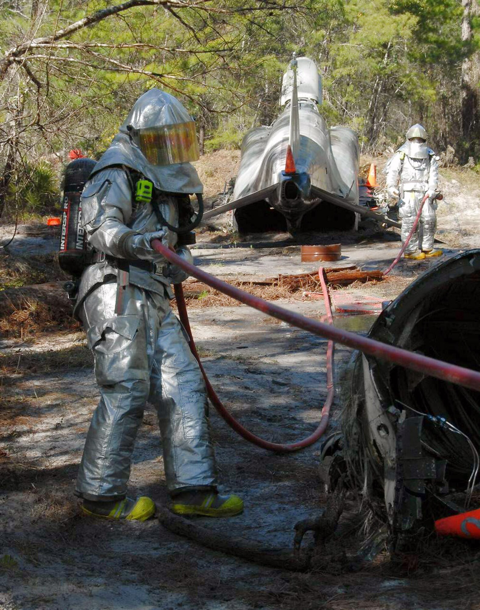 A firefighter with the 104th Fighter Wing pulls a water hose from a fire truck during a Silver Flag exercise at Tyndall Air Force base, Fla., Feb. 5. Silver Flag is training for Air Force members to learn new skills in a simulated combat environment. (U.S. Air Force photo/Tech. Sgt. Melanie Casineau) 