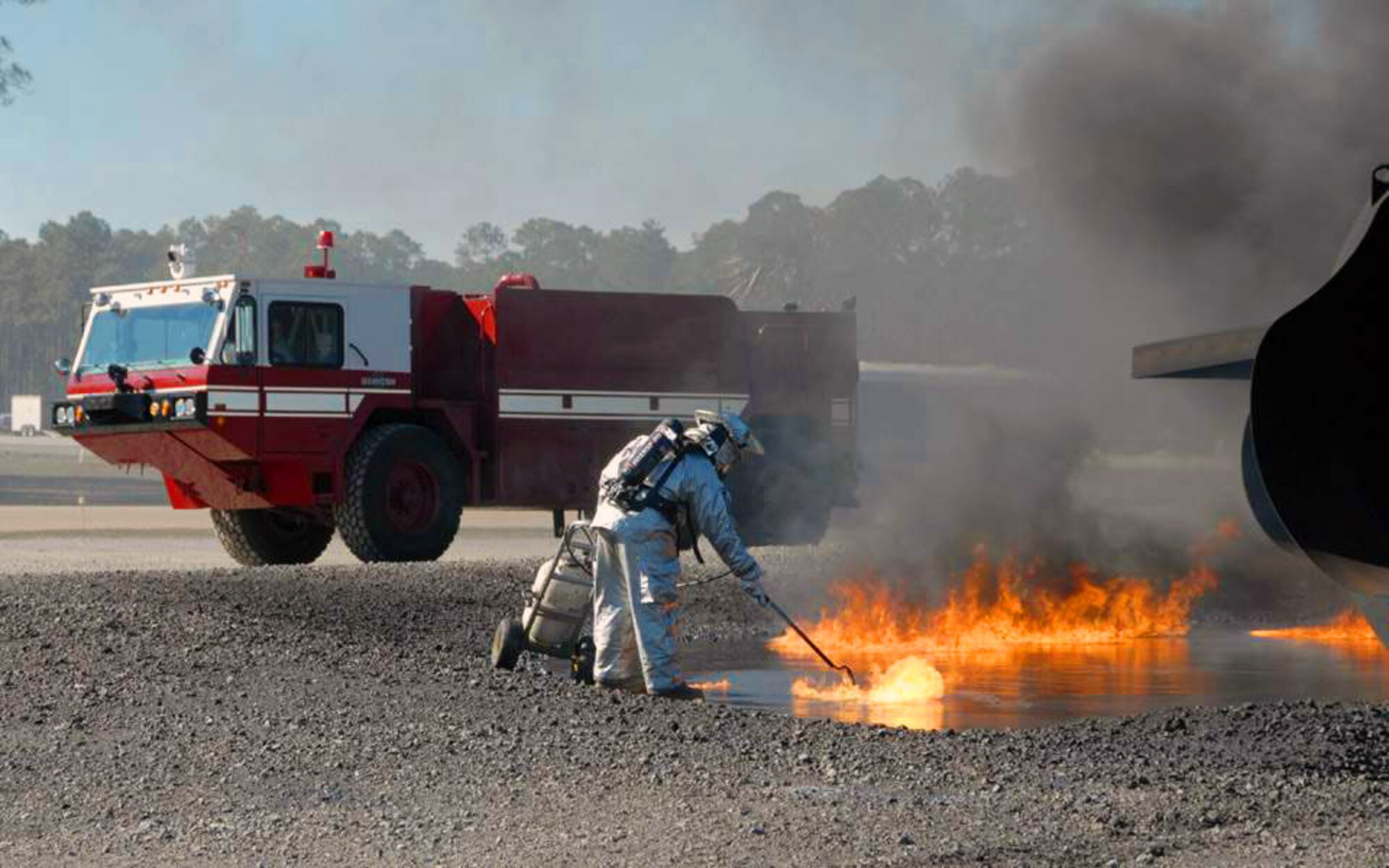 A military firefighter ignites fuel in a fire pit to start a live fire training exercise conducted during a Silver Flag exercise Feb. 4. Silver Flag exercise is an annual training exercise conducted at Tyndall Air Force Base, Fla., to train military personnel within their career fields. (U.S. Air Force photo/Senior Master Sgt. Robert J. Sabonis) 
