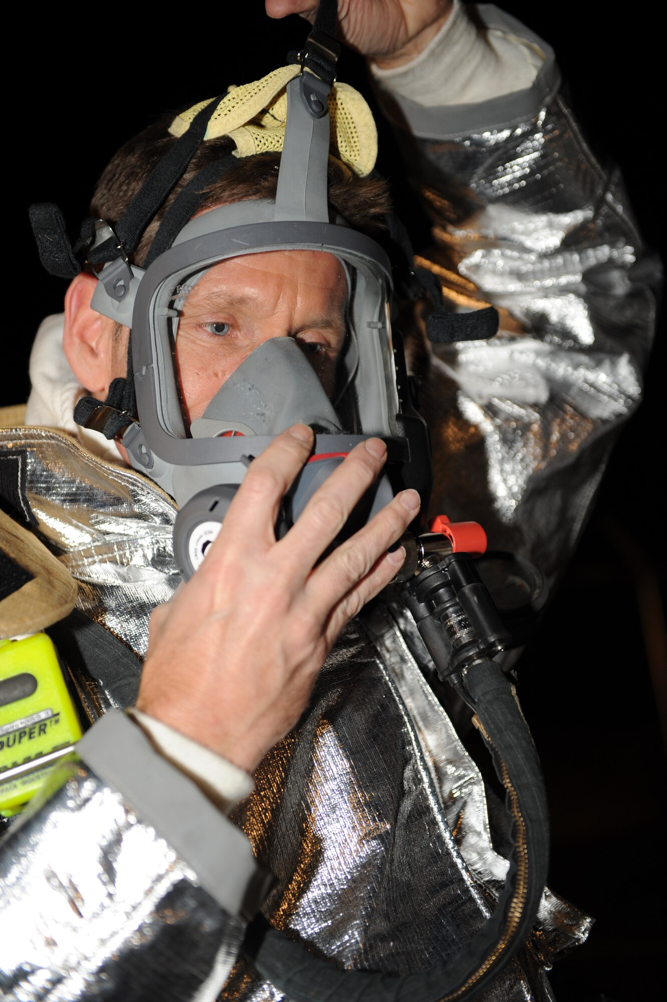 Col. Peter Castor, 28th Bomb Wing vice commander, puts on a self-contained breathing apparatus before partaking in structural burn training here, Feb. 5. The SCBA protects the face from heat and other debris while allowing firefighters to breathe clean oxygen. (U.S. Air Force photo/Airman 1st Class Joshua J. Seybert)