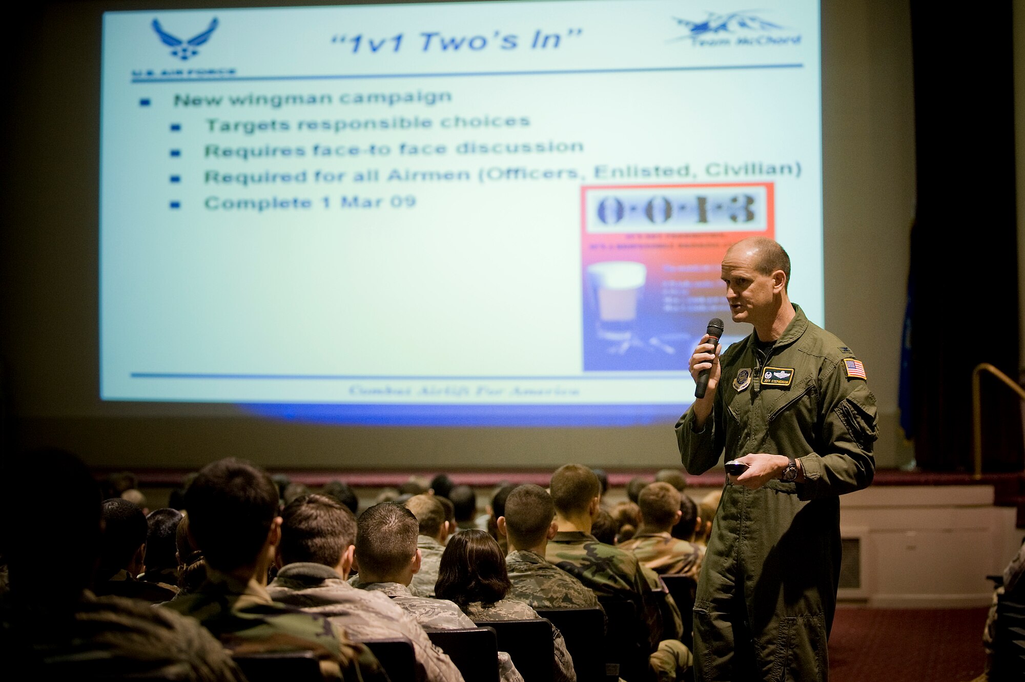 Col. Jeffrey Stephenson, 62nd AW commander, details the new wingman campaign, “1v1, Two’s in” at an Airman’s Call Feb. 4 at the base theater. The new program encourages supervisors to individually meet with each direct-reporting Airman, look them in the eyes and have a personal discussion on responsible drinking behavior and wingman responsibilities as they relate to Air Force core values and the Airman’s personal career and life goals. (U.S. Air Force photo/Abner Guzman)