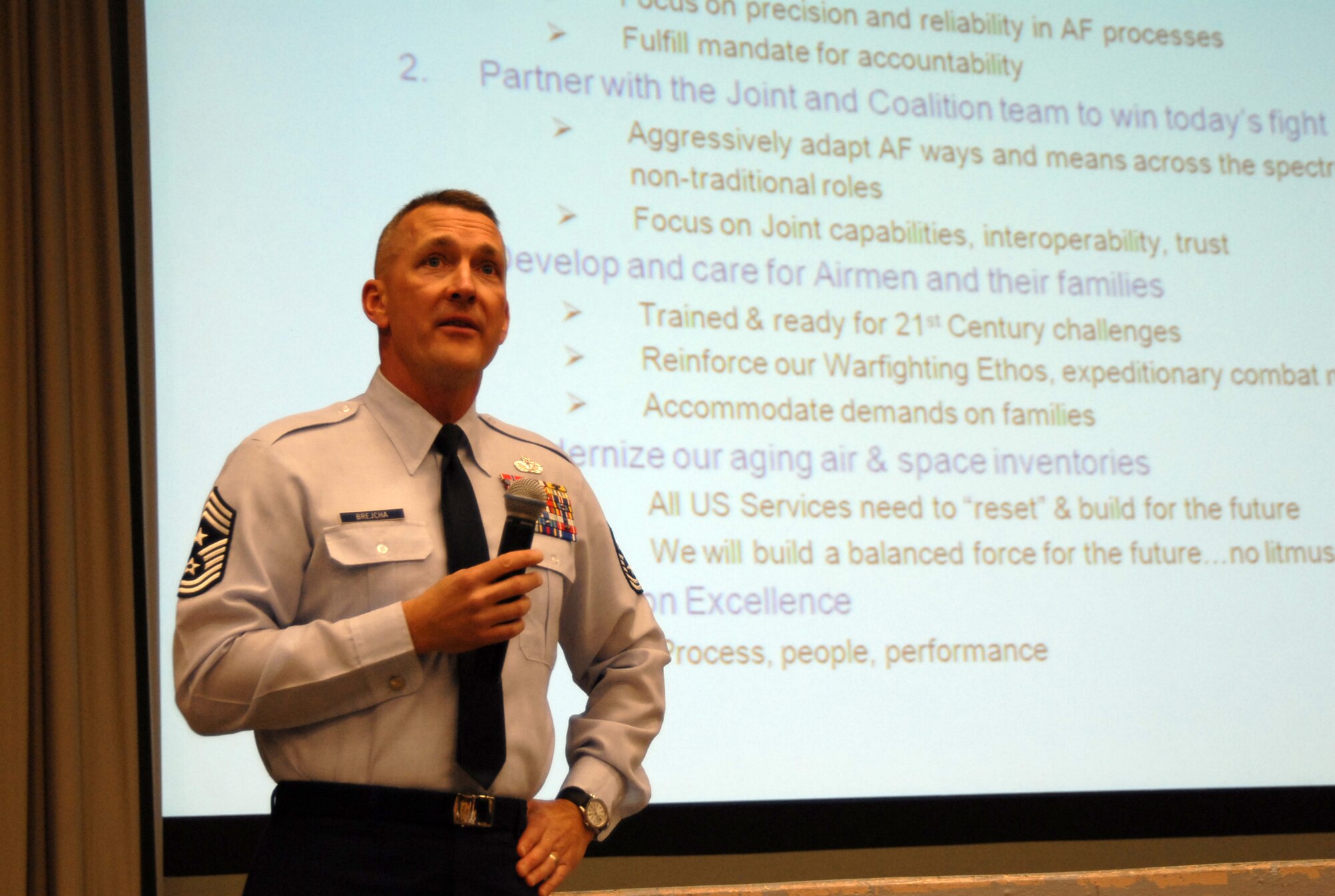 Chief Master Sgt. Mark Brejcha, 412th Test Wing command chief, talks about the Community College of the Air Force degrees during the basewide enlisted call at the base theater Feb. 2. Topics such as educational opportunities on base, strategic communication, driving under the influence, physical fitness testing and dormitory updates were discussed during the enlisted call. (Air Force photo by Senior Airman Julius Delos Reyes)