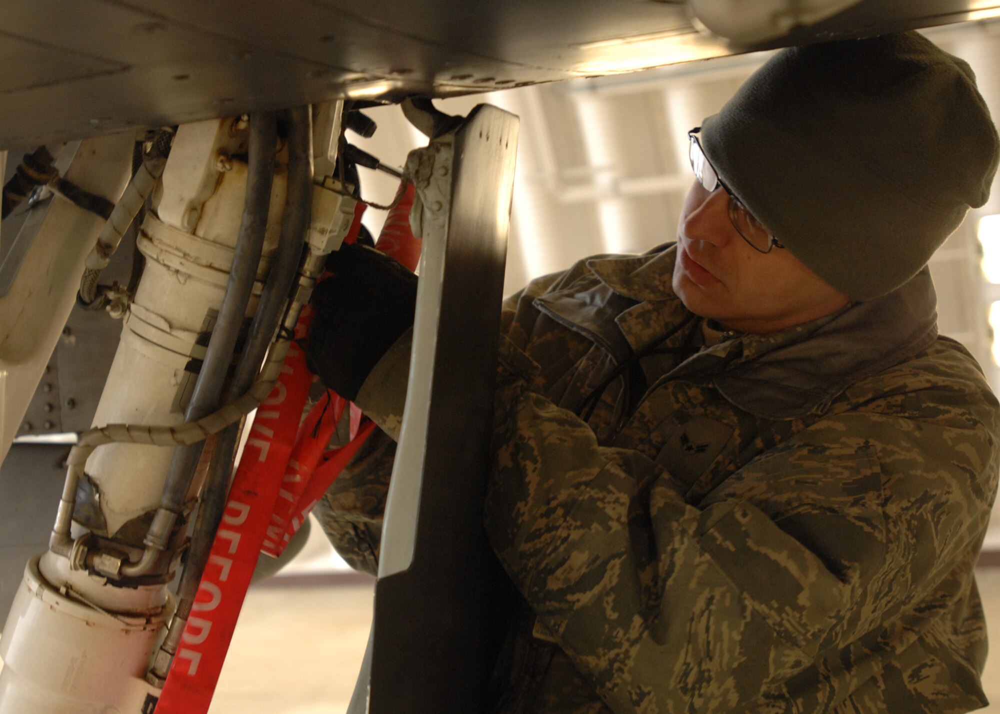 SPANGDAHLEM AIR BASE, Germany -- Airman 1st Class Christopher Snodgrass, 52nd Air Maintenance Squadron, inspects the nose strut actuator on an A-10 Warthog Jan. 28, 2009.  A routine pre-flight inspection is completed prior to the launch of the aircraft. (U.S. Air Force photo by Senior Airman Jenifer H. Calhoun)