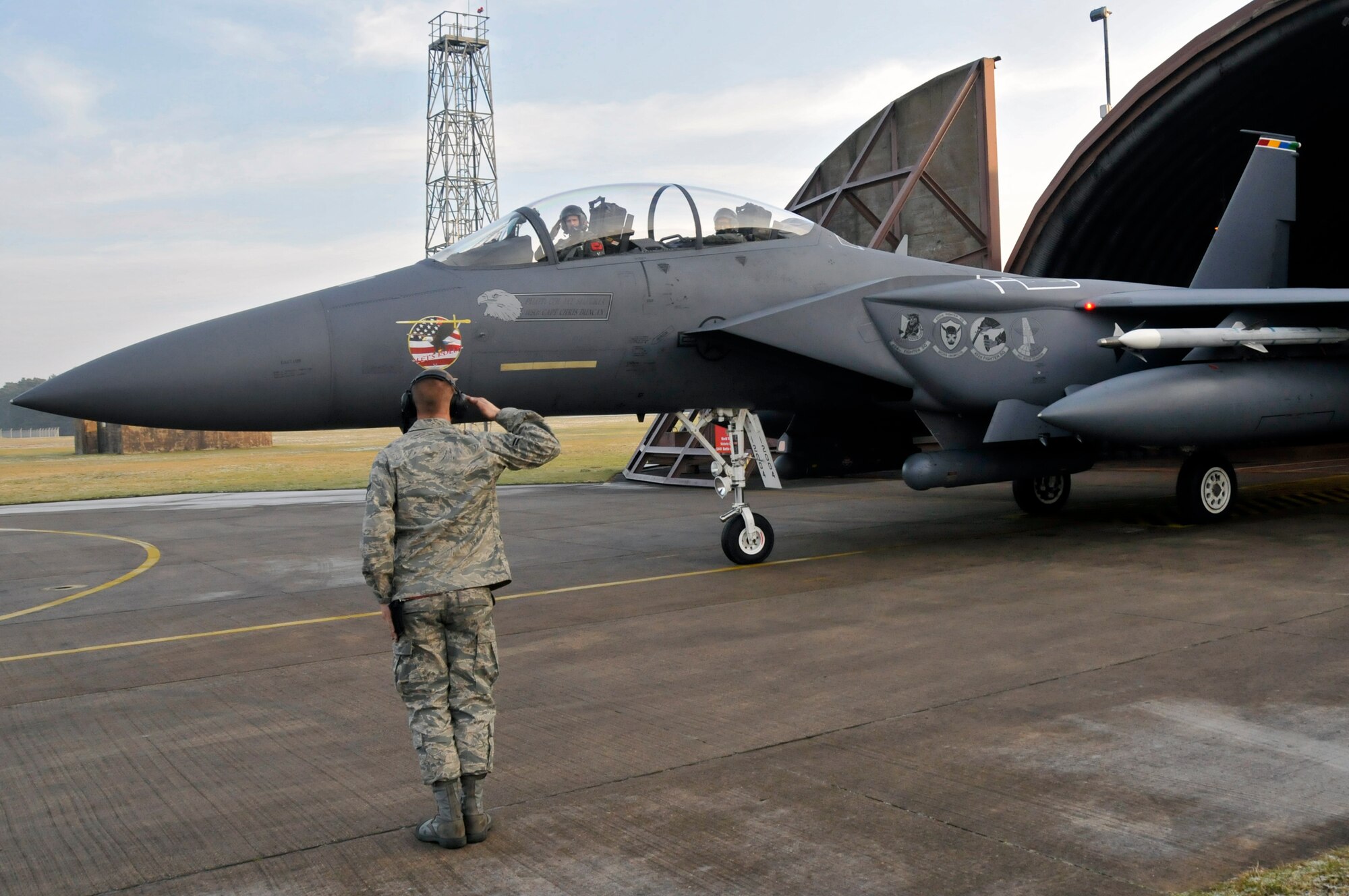 Airman 1st Class Richard Anderson, 48th Aircraft Maintenance Squadron crew chief salutes Maj. Tom Laitinen 494th Fighter squadron F-15E Strike Eagle pilot and Maj. Gen. Mark T. Matthews, Director of Requirements, Headquarters Air Combat Command, a previous 48th Fighter Wing commander, before they taxi to the runway for his F-15E orientation flight with the 494th Fighter Squadron, Jan. 30 at RAF Lakenheath, England. (U.S. Air Force photo by Airman 1st Class Perry Aston) 