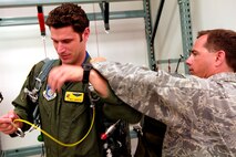 HICKAM AFB - 15th Airlift Wing Survival Evasion Resistance Escape (SERE) Instructor, Tech Sgt. Sherwood Brown of Muscatine, Iowa instructs  aids Los Gatos, Calif. native Maj Will Martin, a pilot with the 535th Airlift Squadron, 15th Airlift Wing with his parachute during refresher parachute training on Jan 24, 2009 at Hickam Air Force Base, Hawaii as one of the four classes that they  teach. (U.S.  Air Force photo/Tech Sgt. Cohen A. Young) 