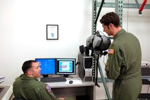 HICKAM AFB - 15th Airlift Wing Survival Evasion Resistance Escape (SERE) Instructor Staff Sgt. Anthony Bittman of Long Beach, Calif. explains the purpose of the virtual parachute simulator to Los Gatos, Calif. native Maj Will Martin, a pilot with the 535th Airlift Squadron, 15th Airlift Wing while conducting refresher parachute training on Jan 24, 2009 at Hickam Air Force Base, Hawaii. Some aircrew members require annual non-ejection parachute training so they are current according to Air Force regulations. (U.S.  Air Force photo/Tech Sgt. Cohen A. Young) 