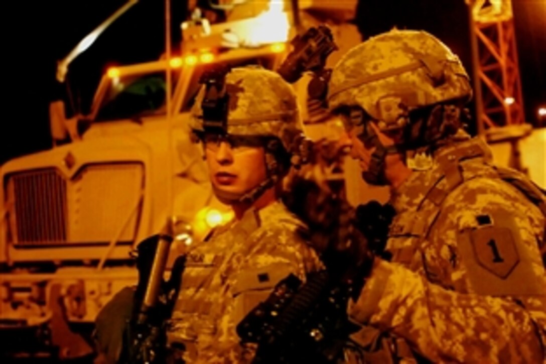 U.S. Army Cpl. Logan Arthur, left, and Staff. Sgt. Troy Watson discuss how to maneuver concrete barriers in front of a voting site in the Washash neighborhood of northwest Baghdad, Iraq, Jan. 25, 2009. Arthur and Watson are assigned to the 1st Infantry Division's 2nd Brigade Combat Team.