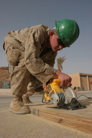 Lance Cpl. Justin Shockley with Engineer Company, Combat Logistics Battalion 2, operates a hand saw aboard Al Asad Air Base, Iraq, that will go into constructing structures aboard the camp.