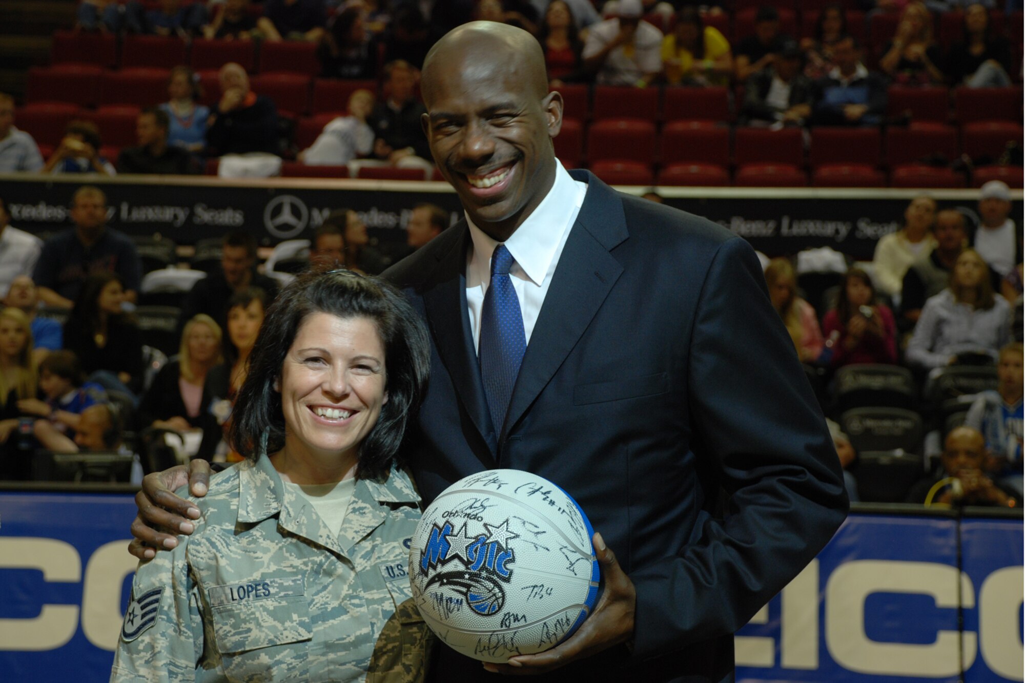 ORLANDO, Fla. -- Charles "Bo" Outlaw, community ambassador for the Orlando Magic basketball team presents a basketball authographed by Magic team members during halftime of their Jan. 9, 2009 game as part of their Seats for Soldiers Night.  U.S. Air Force photo/Master Sgt. Bryan Ripple