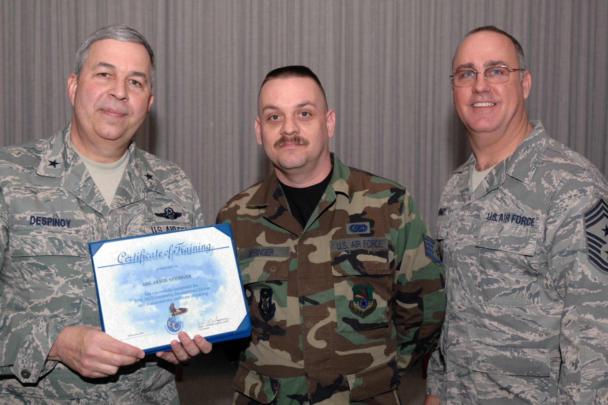 GRISSOM AIR RESERVE BASE, Ind., -- Brig. Gen. Dean Despinoy, 434th Air Refueling Wing commander, left, presents a certificate to Staff Sgt. Jason Springer, 434th Logistics Readiness Squadron, center, for his completion of the NCO Leadership Development Course. Chief Master Sgt. Larry Brady, 434th ARW command chief, is also pictured. (U.S. Air Force photo/Tech. Sgt. Doug Hays)