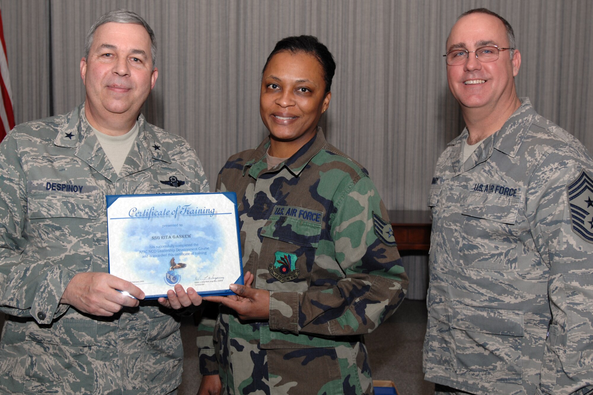 GRISSOM AIR RESERVE BASE, Ind., -- Staff Sgt. Rita Gaskew, 434th Operations Support Squadron, is flanked Brig. Gen. Dean Despinoy, 434th Air Refueling Wing commander, left, and Chief Master Sgt. Larry Brady, 434th ARW command chief, as she is presented a certificate for completing the NCO Leadership Development Course. (U.S. Air Force photo/Tech. Sgt. Doug Hays)