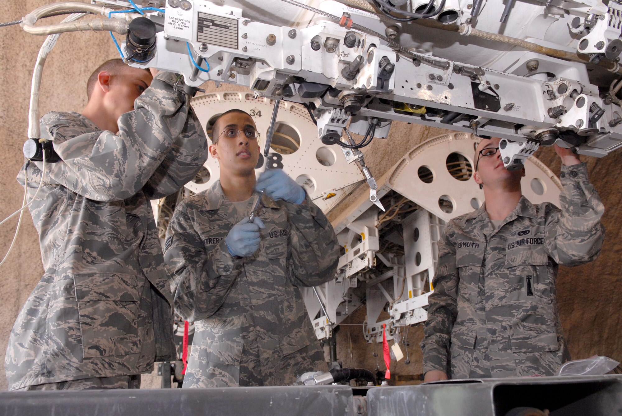 Airman 1st class Thomas Schugg, Senior Airman Diego Contreras, and Airman 1st Class Christopher Germuth, 379th Expeditionary Maintenance Squadron Armament Team Members, secure a BRU-56 30 inch bomb rack to a Multi-Purpose Rotary Launcher (MPRL) taken from a B-1B Lancer for routine maintenance, Feb. 6, 2009, at an undisclosed location in Southwest Asia.  Airman 1st Class Schugg hails from Conyers, Ga., Senior Airman Contreras is from Lexington, Ky. and Airman 1st Class Germuth is from Chester Md.  All three Airmen are deployed from Dyess Air Force Base, Texas in support of Operation Iraqi and Enduring Freedom and Combined Joint Task Force- Horn of Africa.  (U.S. Air Force Photo by Airman 1st Class Andrew Satran/Released)