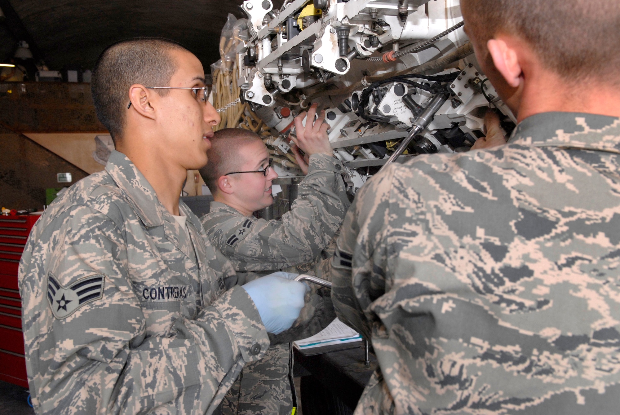 Senior Airman Diego Contreras, Airman 1st Class Christopher Germuth and Airman 1st class Thomas Schugg, 379th Expeditionary Maintenance Squadron Armament Team Members, secure a BRU-56 30 inch bomb rack to a Multi-Purpose Rotary Launcher (MPRL) taken from a B-1B Lancer for routine maintenance, Feb. 6, 2009, at an undisclosed location in Southwest Asia.  Airman 1st Class Schugg hails from Conyers, Ga., Senior Airman Contreras is from Lexington, Ky. and Airman 1st Class Germuth is from Chester, Md.  All three Airmen are deployed from Dyess Air Force Base, Texas in support of Operation Iraqi and Enduring Freedom and Combined Joint Task Force- Horn of Africa.  (U.S. Air Force Photo by Airman 1st Class Andrew Satran/Released)