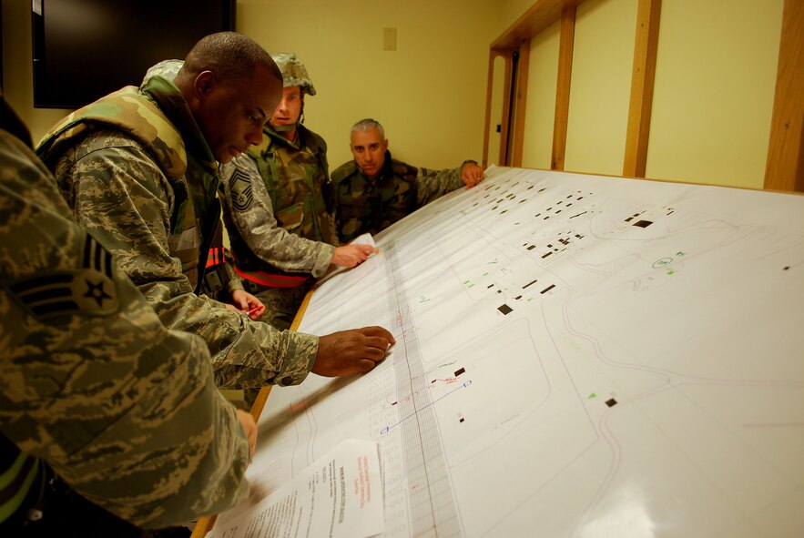 Lt. Col. Dwayne Thomas, troop commander, and other members of Team Hickam plot exercise airfield damage on a Minimum Airfield Operation Strip during a Silver Flag exercise held at Kadena Air Base, Japan, Jan. 18-24. Silver Flag is a week-long event which provides expeditionary combat support training to Airmen in the civil engineer, personnel services, contracting and services career fields, preparing them for upcoming deployments to support deployments around the world. (Air Force photo/Master Sgt. Bobby Duncan)