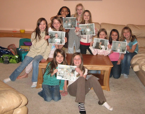Members of Girl Scout Troop 827 in Highlands Ranch, Colo., showcase their accomplishments recently after receiving photos from deployed members of the 302nd Security Forces Squadron. The girl scouts, who send thank you letters to troops each year, found their way to the 302nd Airlift Wing after a series of setbacks in sending letters and ornaments overseas. (Courtesy photo)