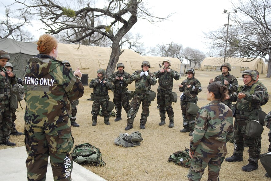 Senior Airman Angela Foster of the 149th Civil Engineering Squadron, 149th Fighter Wing, Texas Air National Guard, conducts a class on the proper donning of chemical warfare protective gear with other members of her unit during a field readiness excercise on February 7, 2009.  The excercise took place at Lackland Air Force Base, Medina Annex, San Antonio, Texas.  (U.S. Air Force Photo by Staff Sgt. Andre' Bullard)