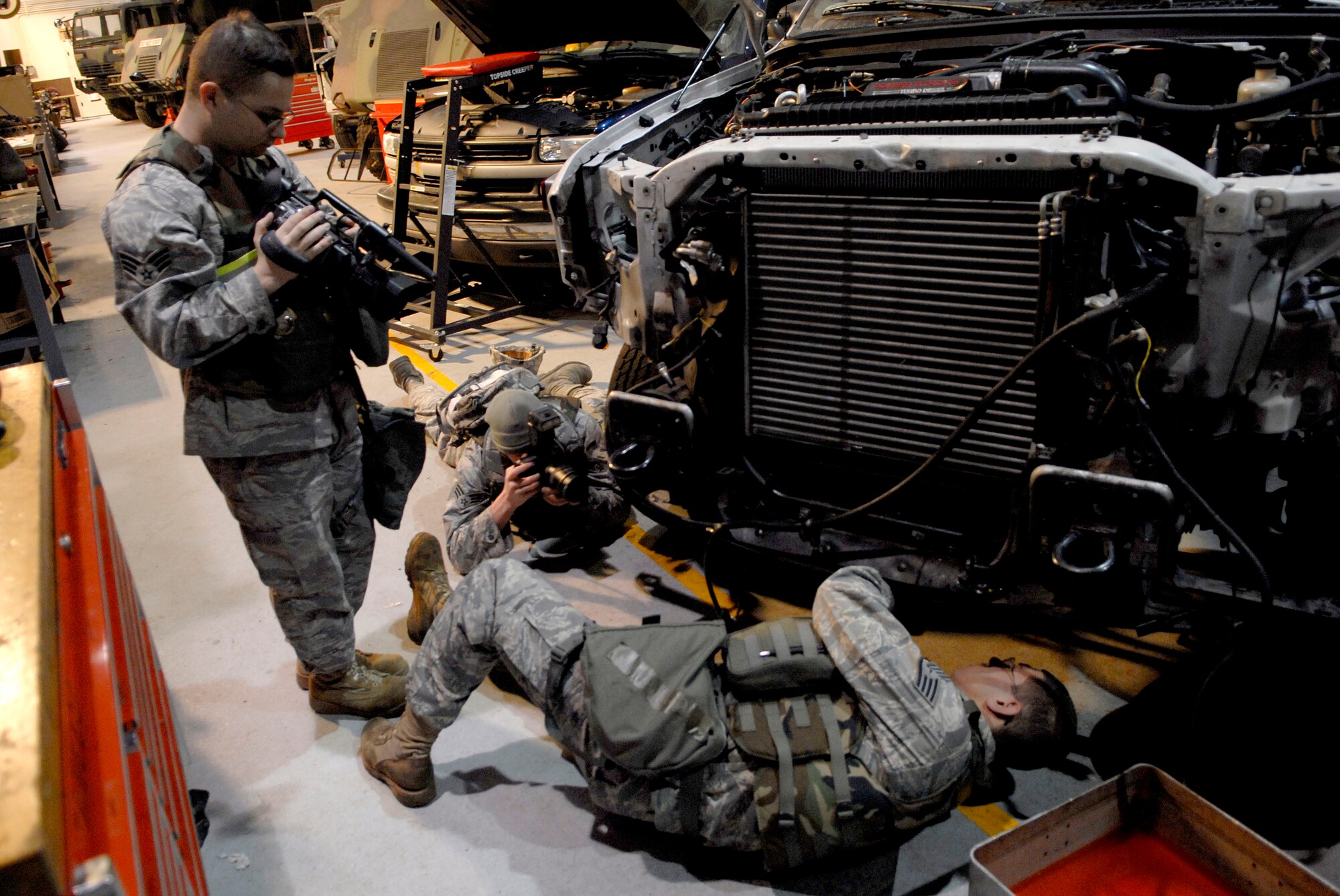 Senior Airmen Christopher Moyeno, (Left),  and Christopher Boitz capture video and photograph documentation of an Airman assigned to the 51st Logistics Readiness Squadron as he disassembles the cooling system of an ambulance in preparation for the 51st Fighter Wing's Operational Readiness Exercise Beverly Midnight 09-01 at Osan AB, Republic of Korea, Feb. 8. Both Airman Moyeno and Boitz are assigned to the 51st Fighter Wing, Public Affairs.  (U.S. Air Force photo/Staff Sgt. Brian Ferguson)
 
