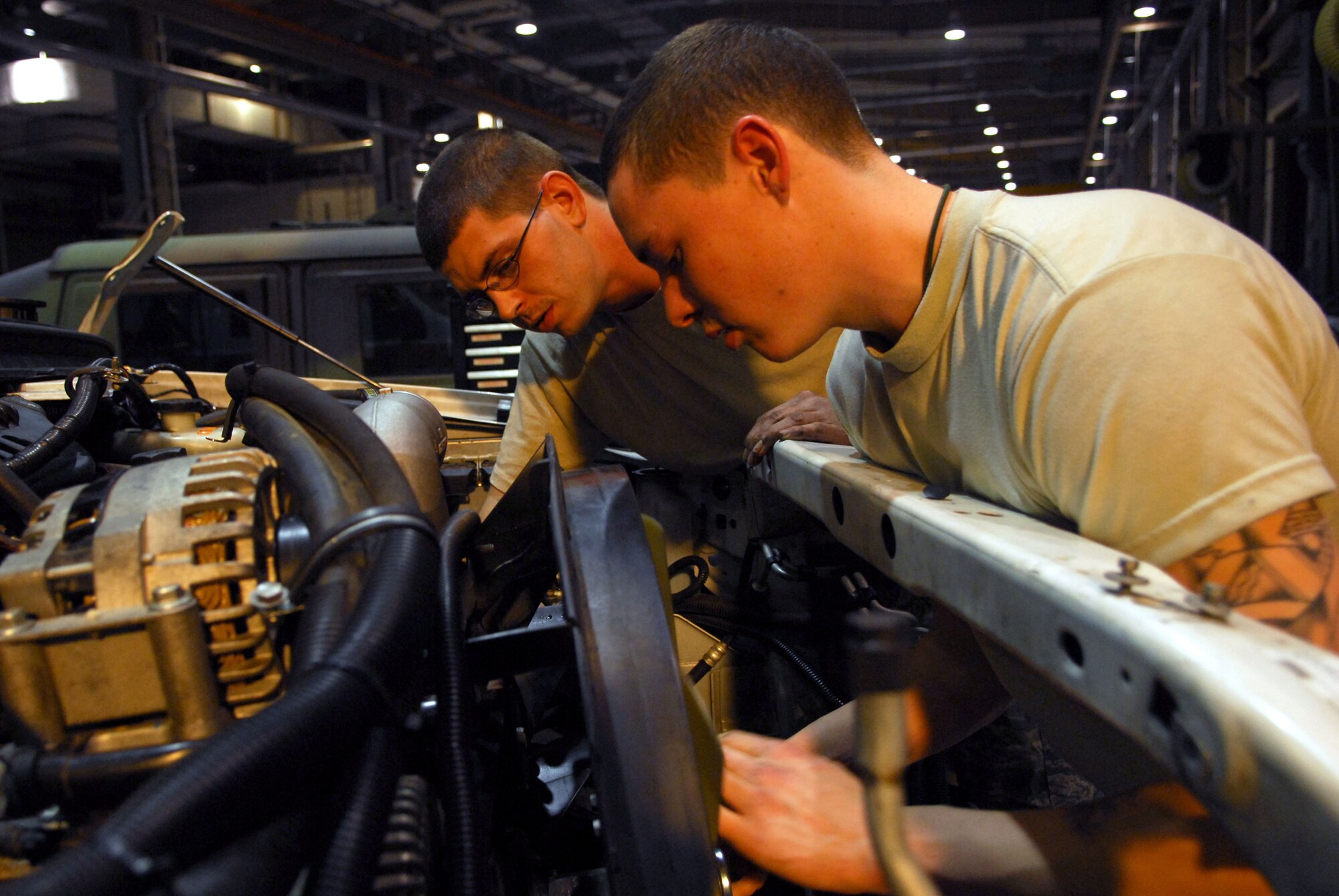 Staff Sgt. John Von Elling and Senior Airman Casey Van Veckhoven disassemble the cooling system of an ambulance during the 51st Fighter Wing’s Operational Readiness Exercise Beverly Midnight 09-01 at Osan AB, Republic of Korea, Feb. 8. The cooling system had to be removed to fix a bent push rod that was stuck in the engine head. Sergeant Von Elling and Airman Van Veckhoven are vehicle maintainers with the 51st Logistic Readiness Squadron.  (U.S. Air Force Photo/Senior Airman Christopher Boitz)
 
