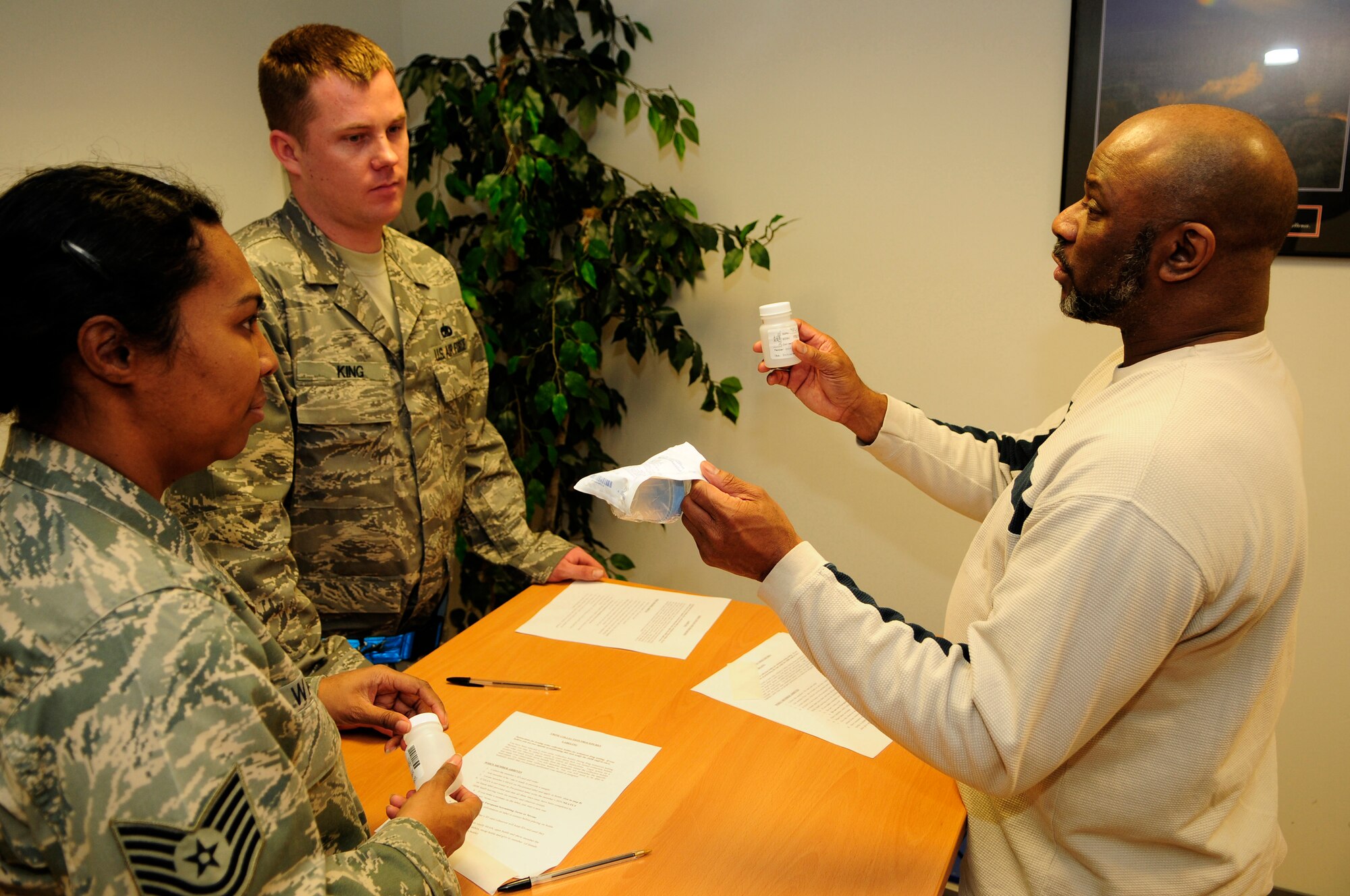 (From left) Tech. Sgt. Lucita Wargel, 735th Civil Engineer Squadron technician, and Staff Sgt. Bryan King, 721st Aircraft Maintenance Squadron maintainer, receive instructions on how to collect urine samples from Jeffrey Kidd, Drug Testing Program administrative manager, during a sobriety checkpoint Feb. 7, 2009, at Ramstein Air Base. Sobriety checkpoints are held randomly throughout the Kaiserslautern Military Community in an effort to enforce a zero-tolerance policy against driving under the influence of drugs and alcohol. (U.S. Air Force photo by Staff Sgt. Stephen J. Otero) 