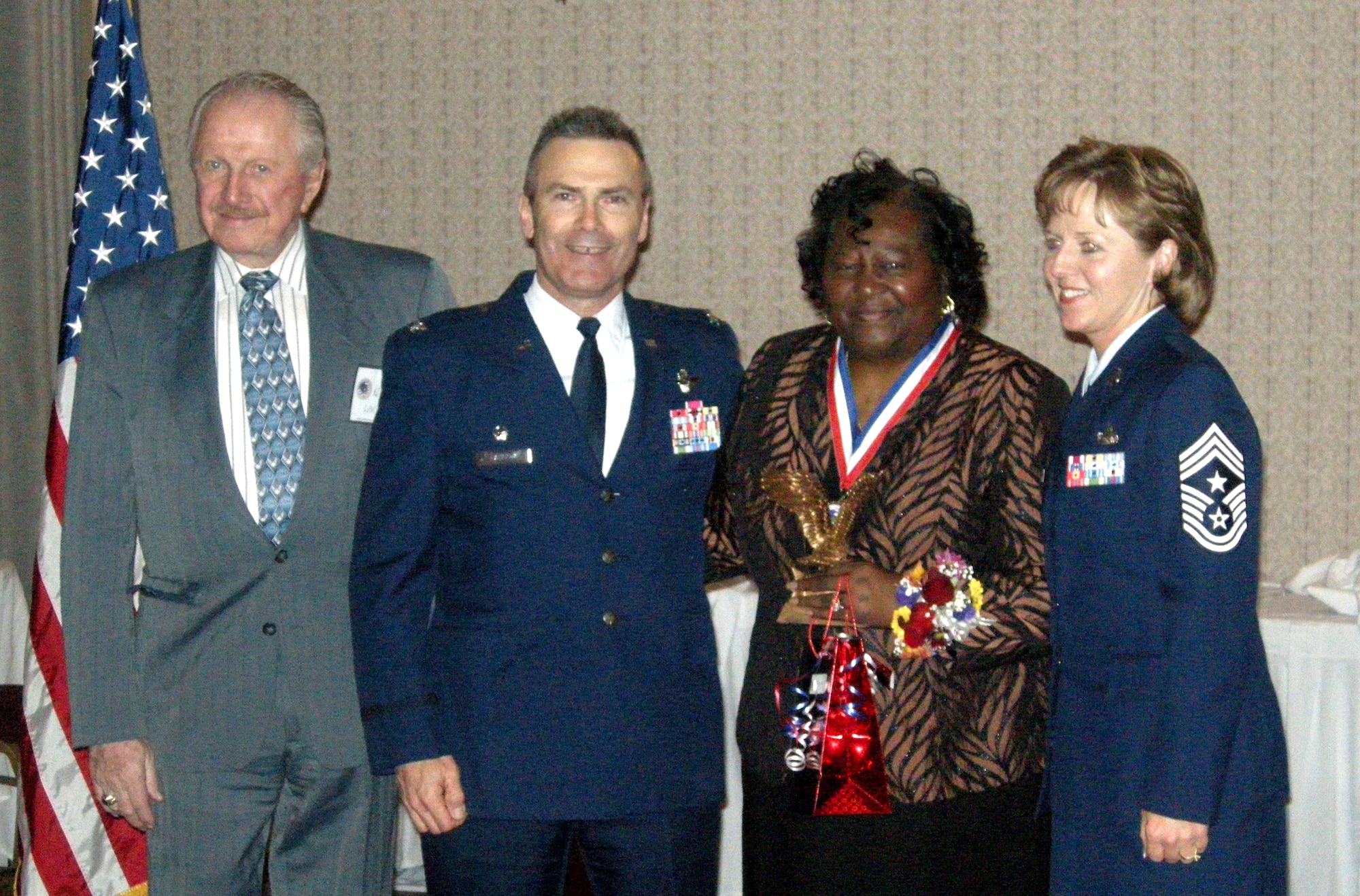 ANDREWS AIR FORCE BASE, Md. -- Retired Lt. Col. Norm Larson, 756th Squadron Association president, Col. Tim Cahoon, 459th Air Refueling Wing commander, and (right) Chief Master Sgt. Patti Hickman, 459th ARW command chief, surround Ms. Cinderella Jones, 459th Communications Flight Civilian of the Year. Ms. Jones had no idea she was even nominated, let alone would win the award. The Fourth Annual Awards banquet took place at the Colony South hotel in Clinton, Md., Feb. 7 and honored military and civilian wing members. (U.S. Air Force photo/Tech. Sgt. Amaani Lyle)