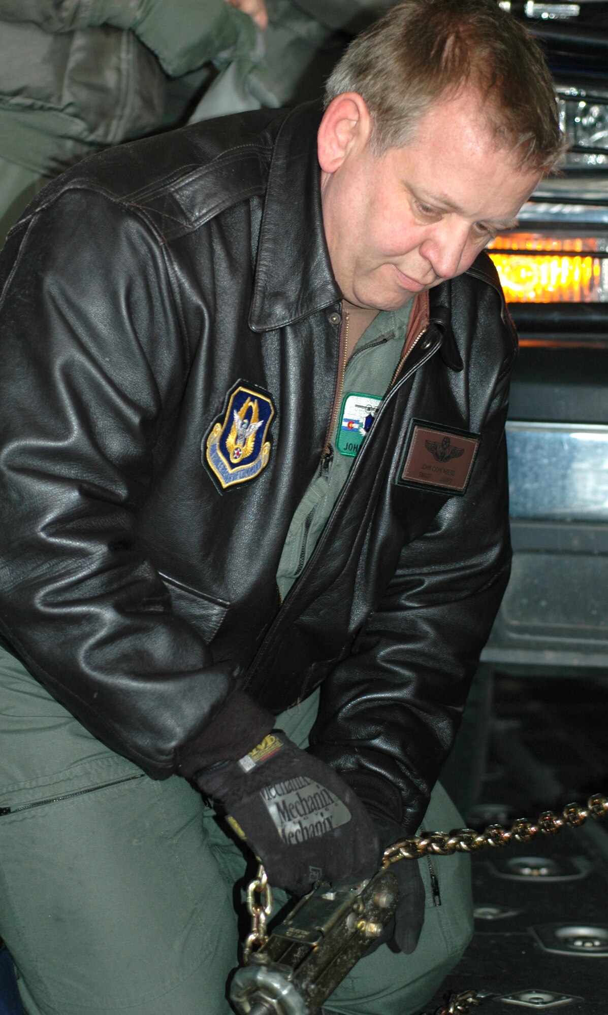 Senior Master Sgt. John "Ice" Eichenberg safely secures a governmnet-owned vehicle to the floor of a C-130 cargo hold Feb. 7, 2009, at Peterson Air Force Base, Colo. Sergeant Eichenberg, 302nd Operations Group airlift control flight superintendent, assisted in providing annual training to loadmasters of the 731st Airlift Squadron on proper loading and tie down procedures, coupled with the same training in chemical warfare gear. Air Force loadmasters are required to perform this type of training annually to comply with Air Force regulations. (U.S. Air Force photo/Senior Airman Stephen Collier)