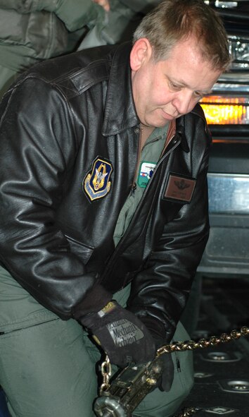Senior Master Sgt. John "Ice" Eichenberg safely secures a governmnet-owned vehicle to the floor of a C-130 cargo hold Feb. 7, 2009, at Peterson Air Force Base, Colo. Sergeant Eichenberg, 302nd Operations Group airlift control flight superintendent, assisted in providing annual training to loadmasters of the 731st Airlift Squadron on proper loading and tie down procedures, coupled with the same training in chemical warfare gear. Air Force loadmasters are required to perform this type of training annually to comply with Air Force regulations. (U.S. Air Force photo/Senior Airman Stephen Collier) 