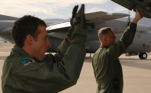 Senior Airman Jared Cleghorn (left) and Tech. Sgt. Joe McWilliams act as spotters to guide a government-owned vehicle into place for proper securing on the floor of a C-130 cargo hold Feb. 7, 2009, at Peterson Air Force Base, Colo. The Airmen participated in mandatory training on proper loading and tie down procedures, coupled with the same training in chemical warfare gear. Air Force loadmasters are required to perform this type of training annually to comply with Air Force regulations. (U.S. Air Force photo/Senior Airman Stephen Collier)