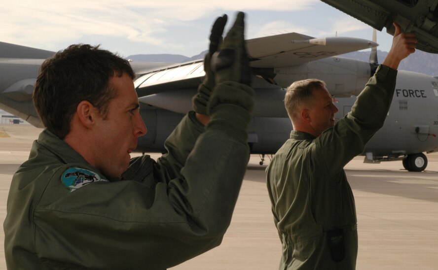 Senior Airman Jared Cleghorn (left) and Tech. Sgt. Joe McWilliams act as spotters to guide a government-owned vehicle into place for proper securing on the floor of a C-130 cargo hold Feb. 7, 2009, at Peterson Air Force Base, Colo. The Airmen participated in mandatory training on proper loading and tie down procedures, coupled with the same training in chemical warfare gear. Air Force loadmasters are required to perform this type of training annually to comply with Air Force regulations. (U.S. Air Force photo/Senior Airman Stephen Collier)