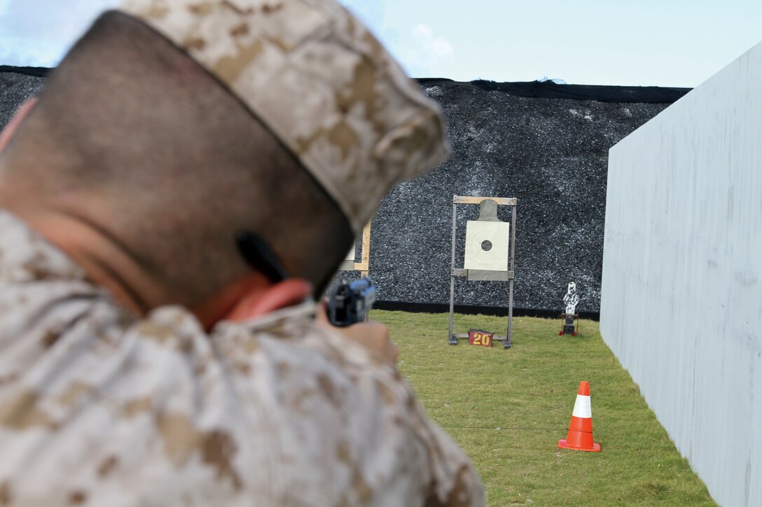 Lance Cpl. Josh DeAses, military policeman, Camp Hansen Provost Marshal’s Office, shoots his annual pistol qualification along with more than 500 PMO Marines and members of the Japanese Security Guard Oct. 25.