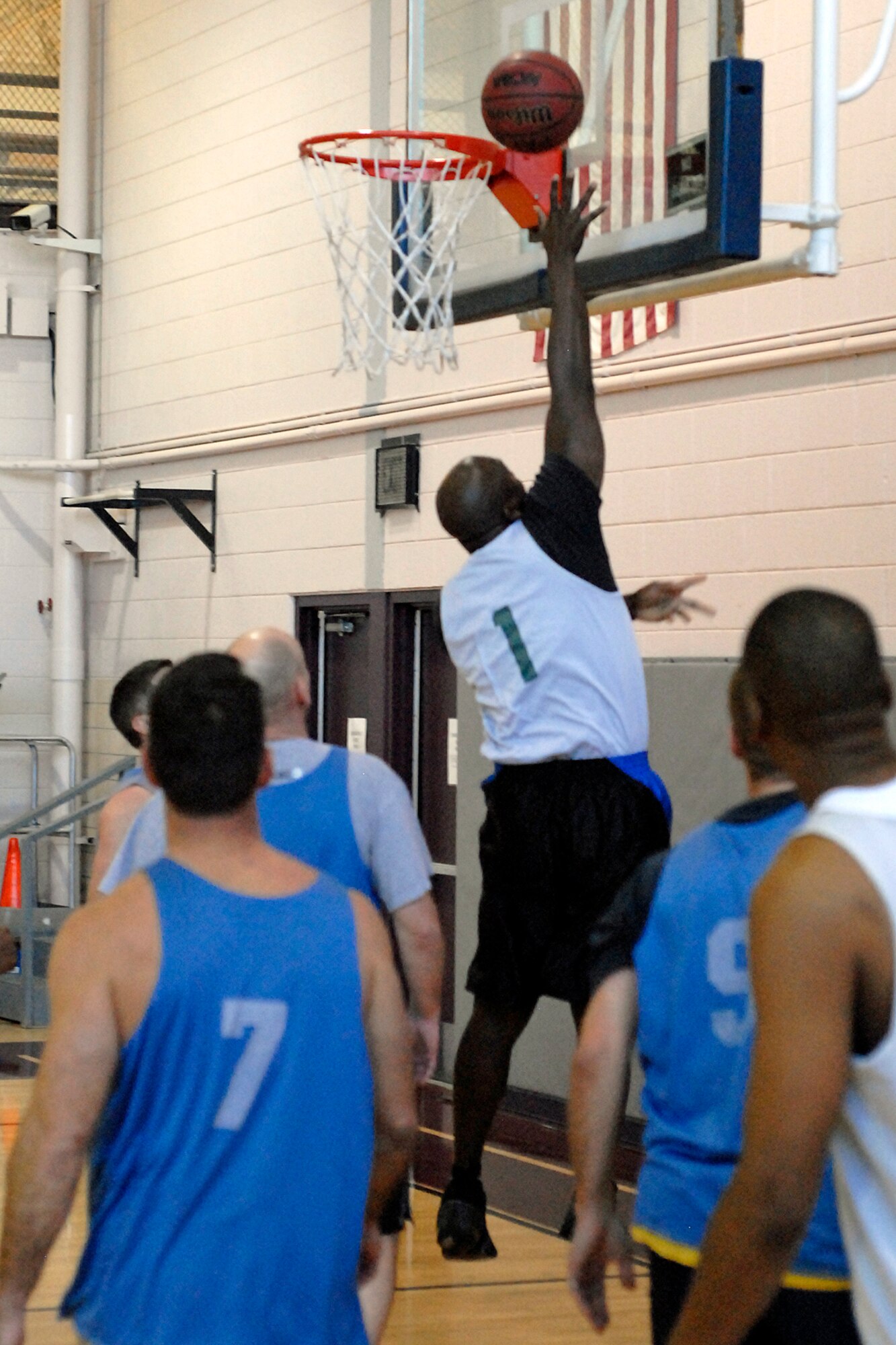 Jeff Russ, # 1, is all alone when he jumps high to score 2 points for the AFSPC home team which won the game.  AFSPC out scored their opponents, 65 to 37, during the Over 30 Intramural Basketball tournament held at Peterson AFB.