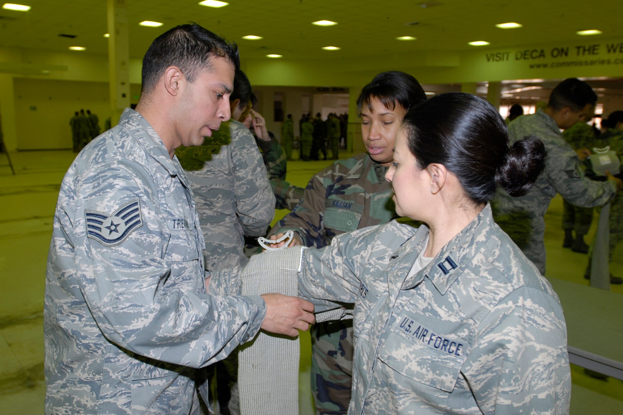 Staff Sgt. Enrique Trevino, 21st Space Wing Logistics Readiness Squadron, wraps a volunteer's arm during Self Aid and Buddy Care training at the old Peterson AFB commissary Jan. 29.