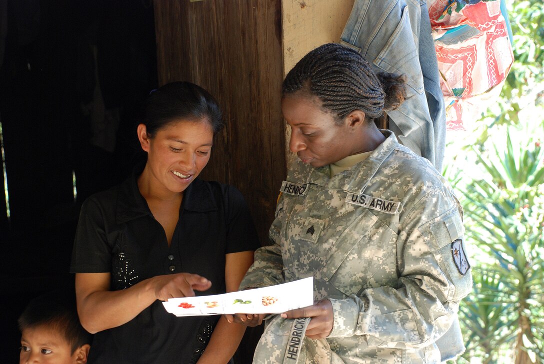 U.S. Army Sgt. Onika Hendricks discusses a variety of locally available foods known to be high in iron and other essential nutrients with a mother living in the remote village of Marcala, Honduras. A team of 16 medical workers and dieticians traveled there from the United States to take part in a pediatric nutrition medical readiness training exercise. The team partnered with specialists from the Honduran Ministry of Health and the medical element of Joint Task Force-Bravo, based at Soto Cano Air Base, Honduras. (U.S. Air Force photo/Tech. Sgt. Mike Hammond)