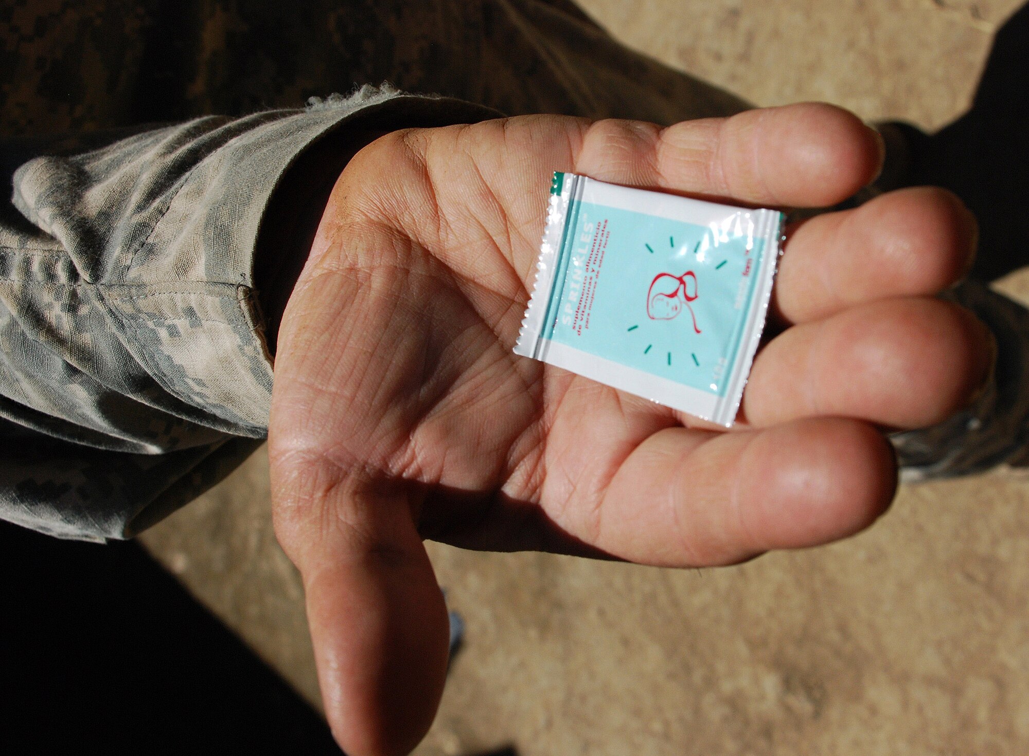 A member of the U.S. military medical readiness and training exercise team visiting the remote village of Marcala, Honduras, holds a packet of micronutrients. The team provided these packets to women of child-bearing age to help specialists with the Honduran Ministry of Health determine the health benefits of including the nutrients in the women's diets. (U.S. Air Force photo/Tech. Sgt. Mike Hammond)