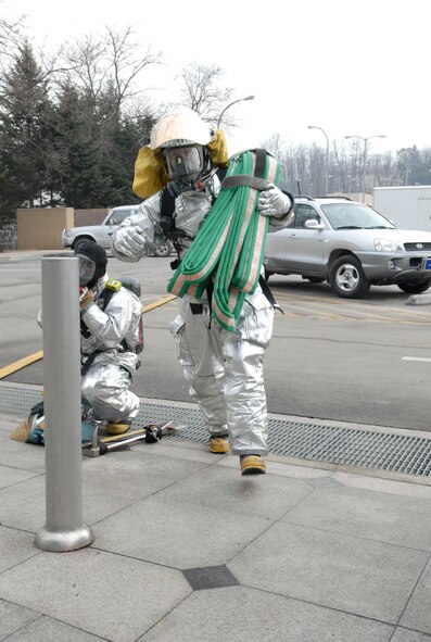 An Airmen from the 51st Civil Engineer Squadron fire department rushes into the 51st Fighter Wing Emergency Operations center with a hose during a simulated fire which caused the emergency operations center to evacuate during the 51st Fighter Wing Operational Readiness Exercise Beverly Midnight 09-01 at Osan, AB, Republic of Korea, Feb. 9.  (US Air Force photo by Staff Sgt. Scottie T. McCord)