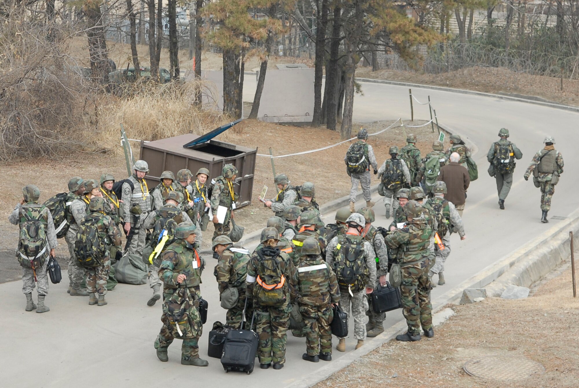 Airmen from the 51st Fighter Wing Emergency Operations center assemble at pre-designated rally points after a simulated fire forces them to conduct a "Bug-out" of the emergency operations center during the 51st Fighter Wing Operational Readiness Exercise Beverly Midnight 09-01 at Osan AB, Republic of Korea, Feb. 8.  "Bug-out" drills are conducted to demonstrate the effectiveness of building occupants to evacuate quickly from a building as quickly and safely as possible. Once accountability is conducted, the emergency operations center Airmen were able to proceeded to their alternate location. (US Air Force photo by Staff Sgt. Scottie T. McCord)
