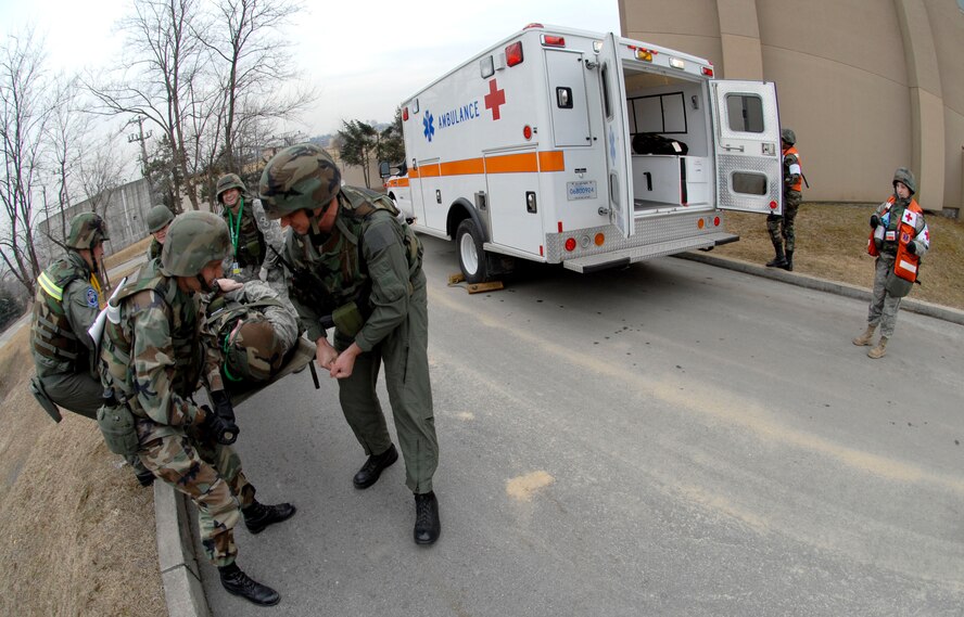 Airmen from the 51st Fighter Wing Emergency Operations Center lift Col. Thomas Deale off the ground and move him to an awaiting ambulance for a simulated broken leg during the 51 FW Operational Readiness Exercise Beverly Midnight 09-01 at Osan AB, Republic of Korea Feb 09. Colonel Deale is the 51st FW Commander. (US Air Force photo by Staff Sgt. Brian Ferguson) 