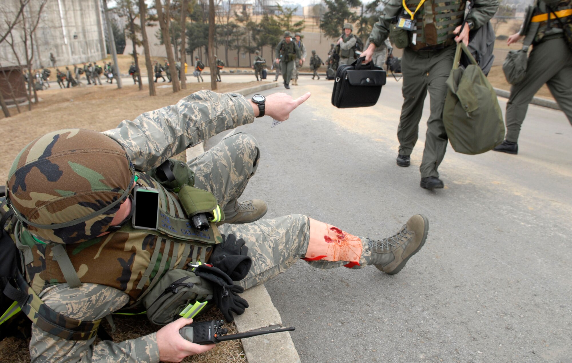 Col. Thomas Deale shouts out to Airmen from the 51st Fighter Wing Emergency Operations center for help after receiving a simulated broken leg during a ?Bug out? of the Emergency Operations Center during 51 FW Operational Readiness Exercise Beverly Midnight 09-01 at Osan, Air Base, Republic of Korea Feb 09. "Bug-out" drills are conducted to demonstrate the effectiveness of building occupants to evacuate quickly from a building as quickly and safely as possible. Colonel Deale is the 51st FW Commander. (US Air Force photo by Staff Sgt. Brian Ferguson)