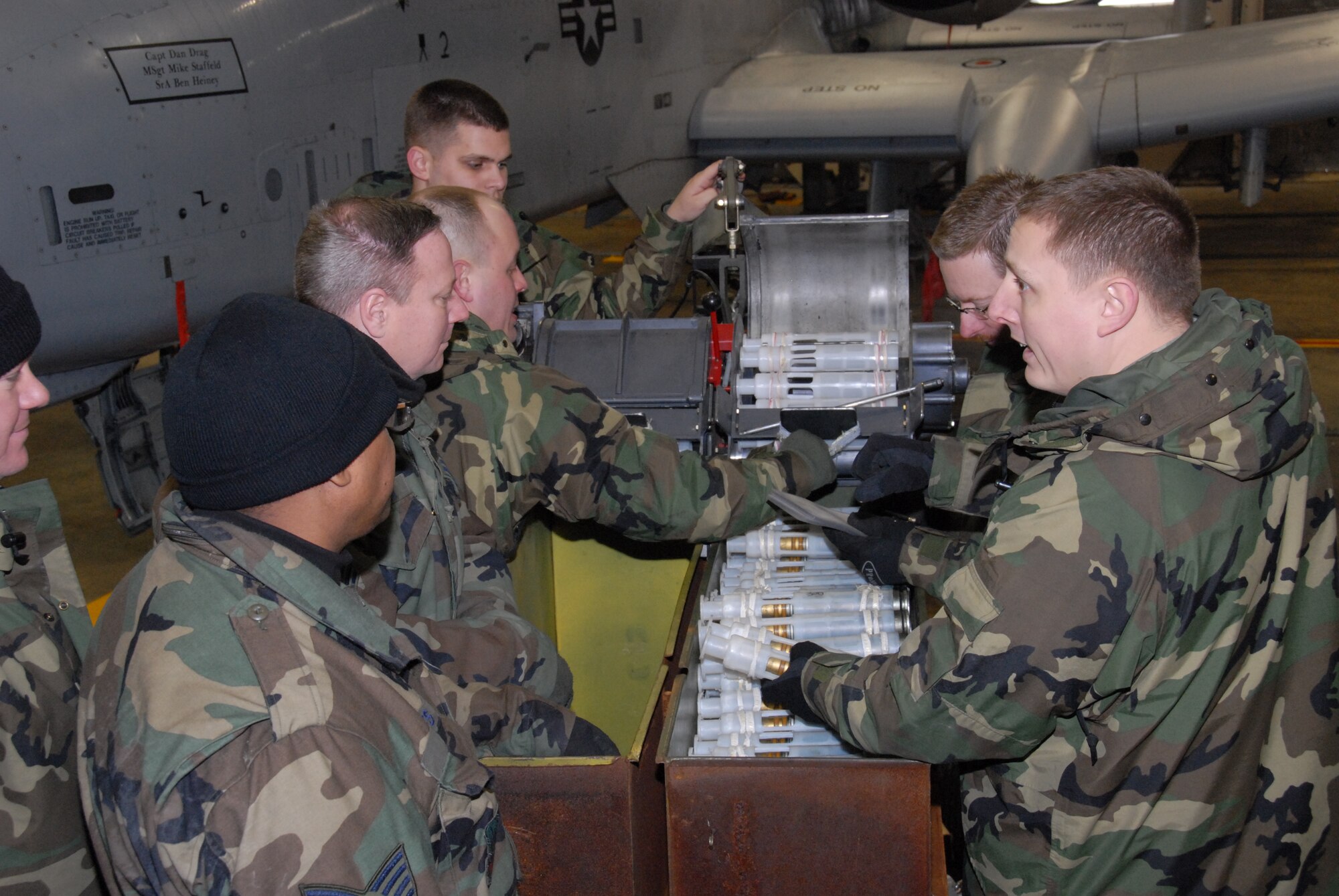 TSgt. Harold Hayes, TSgt. Jared Bicker, TSgt. Jim Ferguson and SrA Jeff Kohler of the 127th Wing's Aircraft Maintenance Squadron were selected to work with instructors TSgt. Bob Mitchell, TSgt. Mike Kerr and TSgt. Andy Amala in a Train-the-Trainer-style program at Selfridge Air National Guard Base. Here they familarize themselves with the Ammunition Loading Adapter, or Dragon, which racks the 1100, 30-millimeter rounds into the A-10 Thunderbolt. The 127th Wing is training on the A-10 as part of its ongoing conversion to the attack aircraft from the F-16. (photo by MSgt. Clancey Pence, 127th Public Affairs)